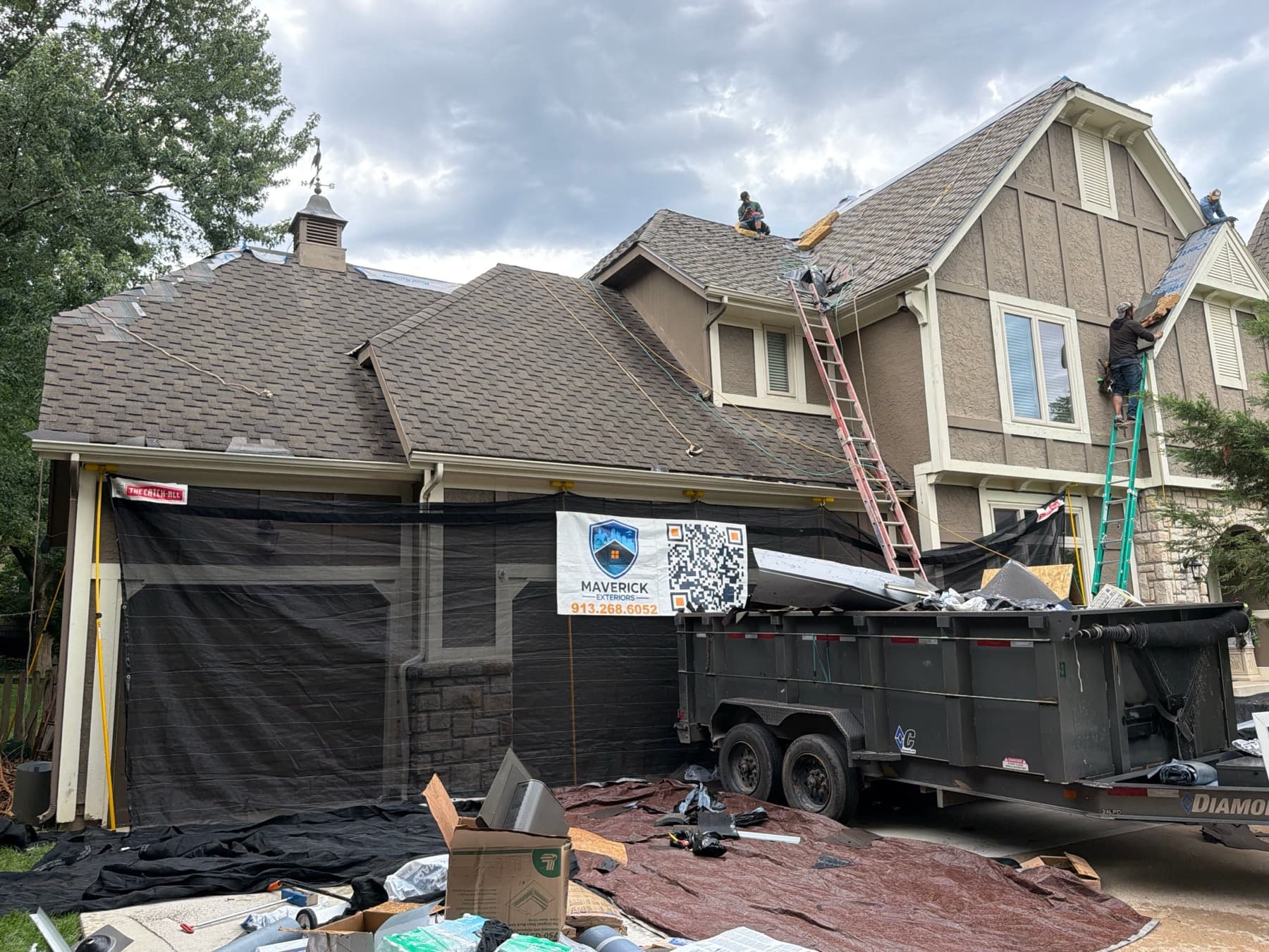 Maverick roof replacement in progress, with protective netting around the front of the house