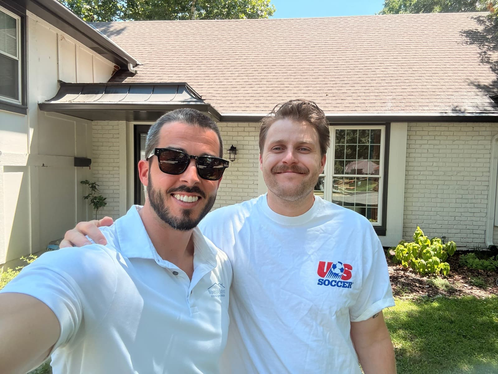 A Maverick team member and homeowner outside a local home